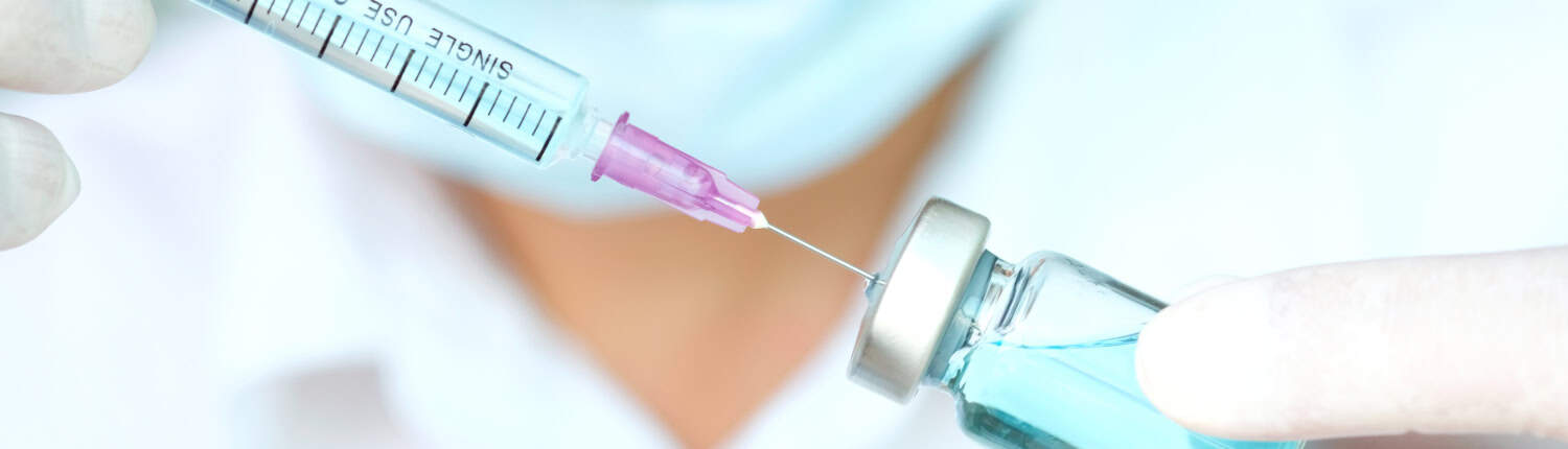 Hand of doctor holding syringe and medicine bottle. Preparing fo